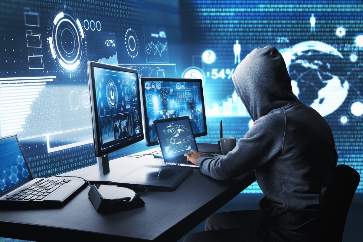hacker usando un ordenador con interfaz digital mientras se sienta en el escritorio